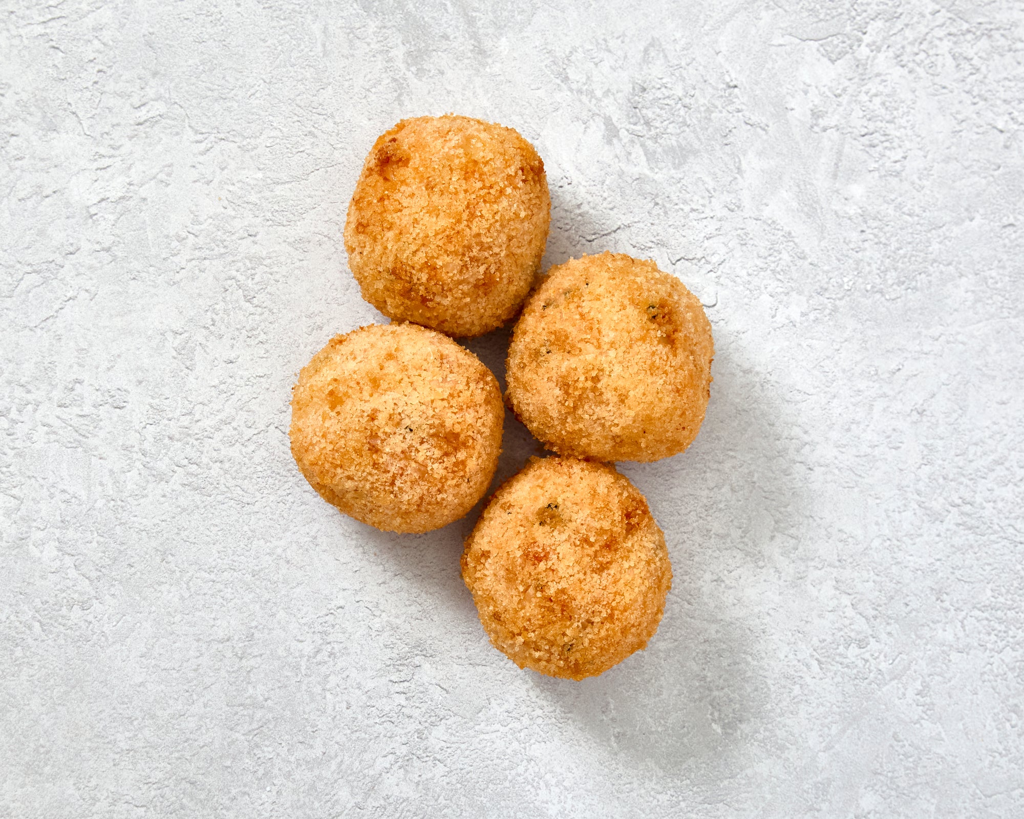 Four Arancini Porcini on a light surface