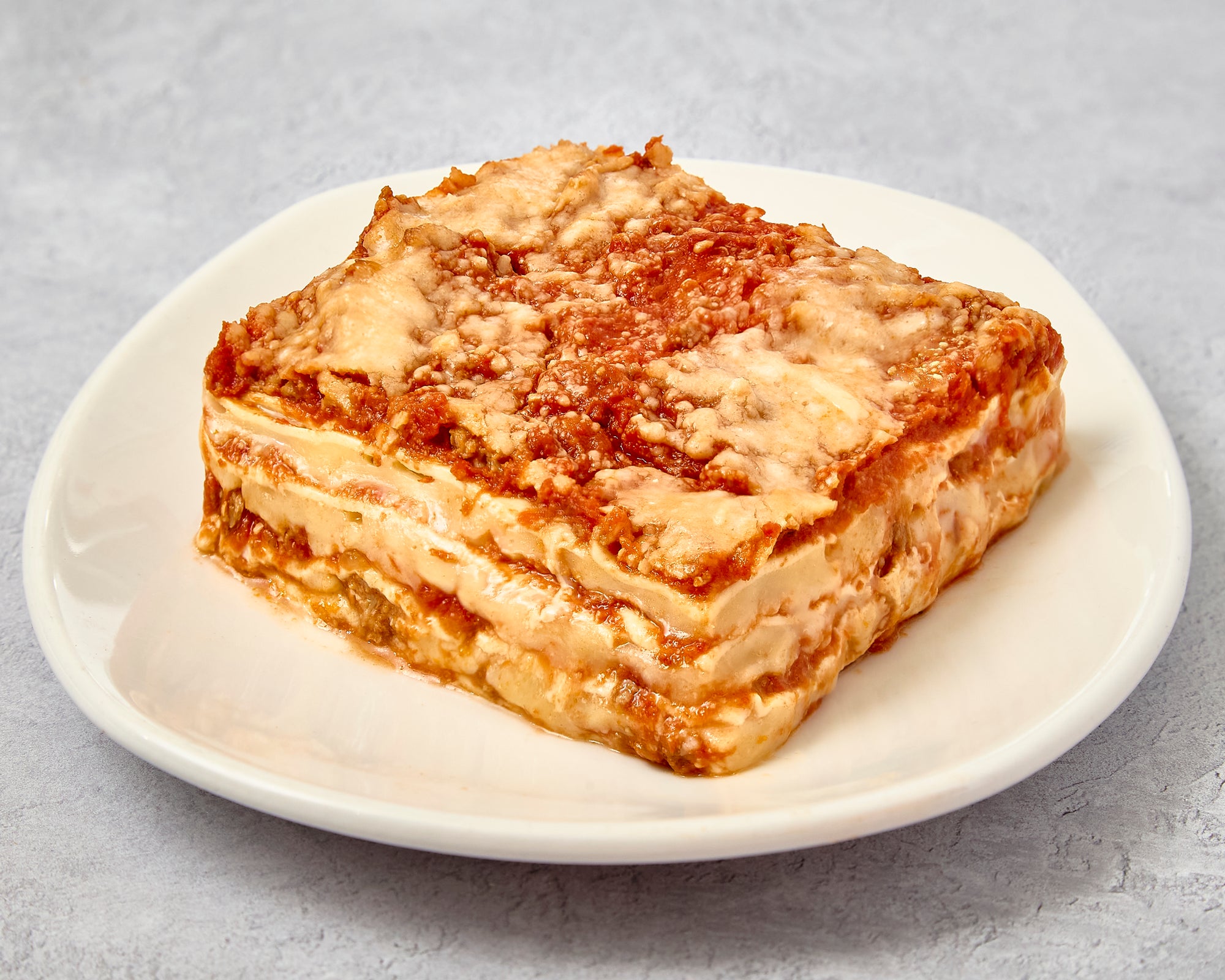 Portion of lasagna beef served on a white plate