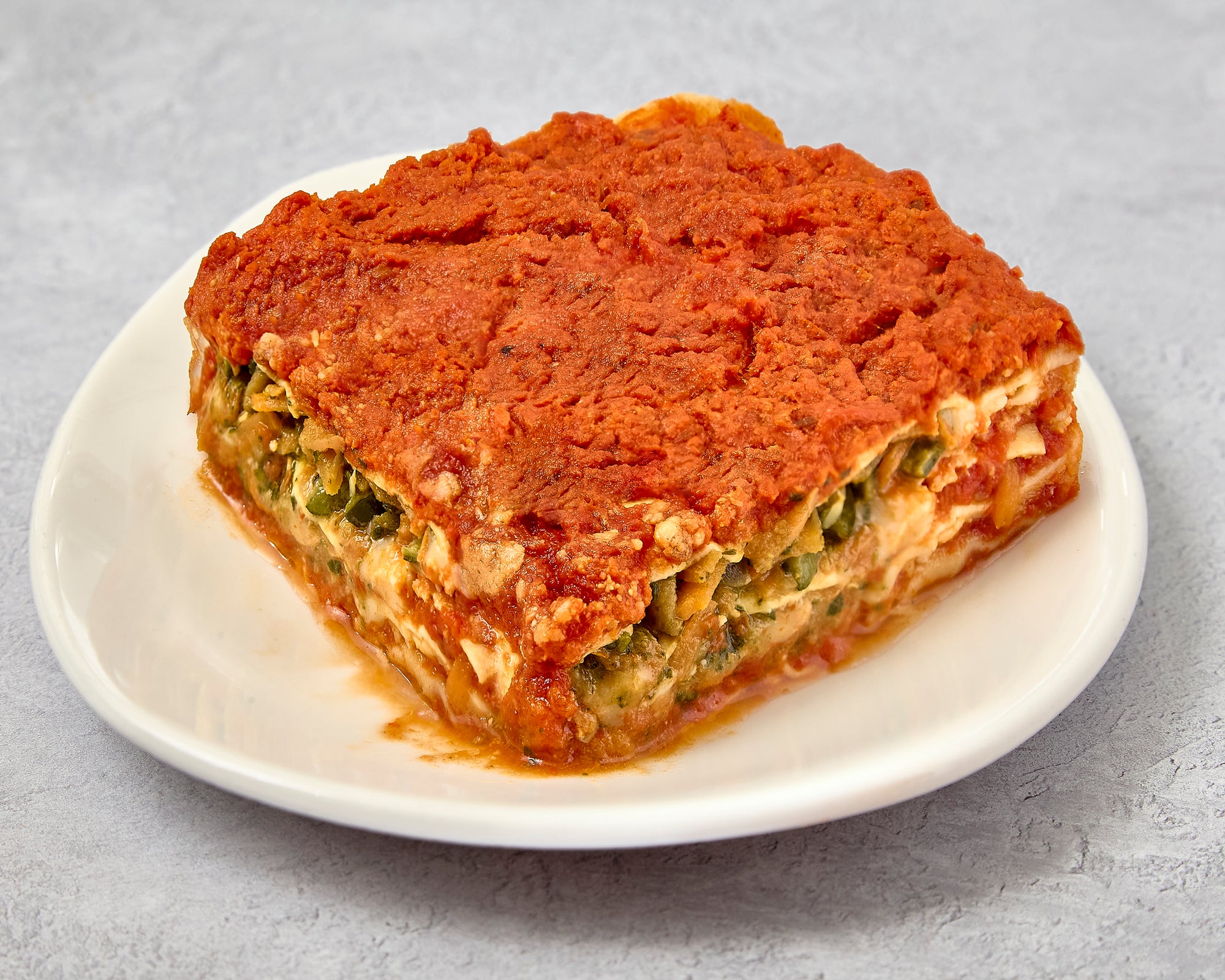 Portion of lasagna vegetarian on a white plate