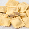 Uncooked cut ravioli showing beef filling