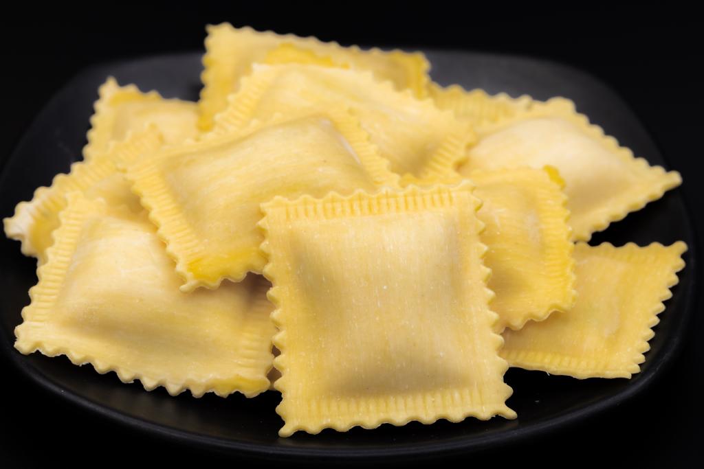 Fresh ravioloni pumpkin arranged on a dark plate