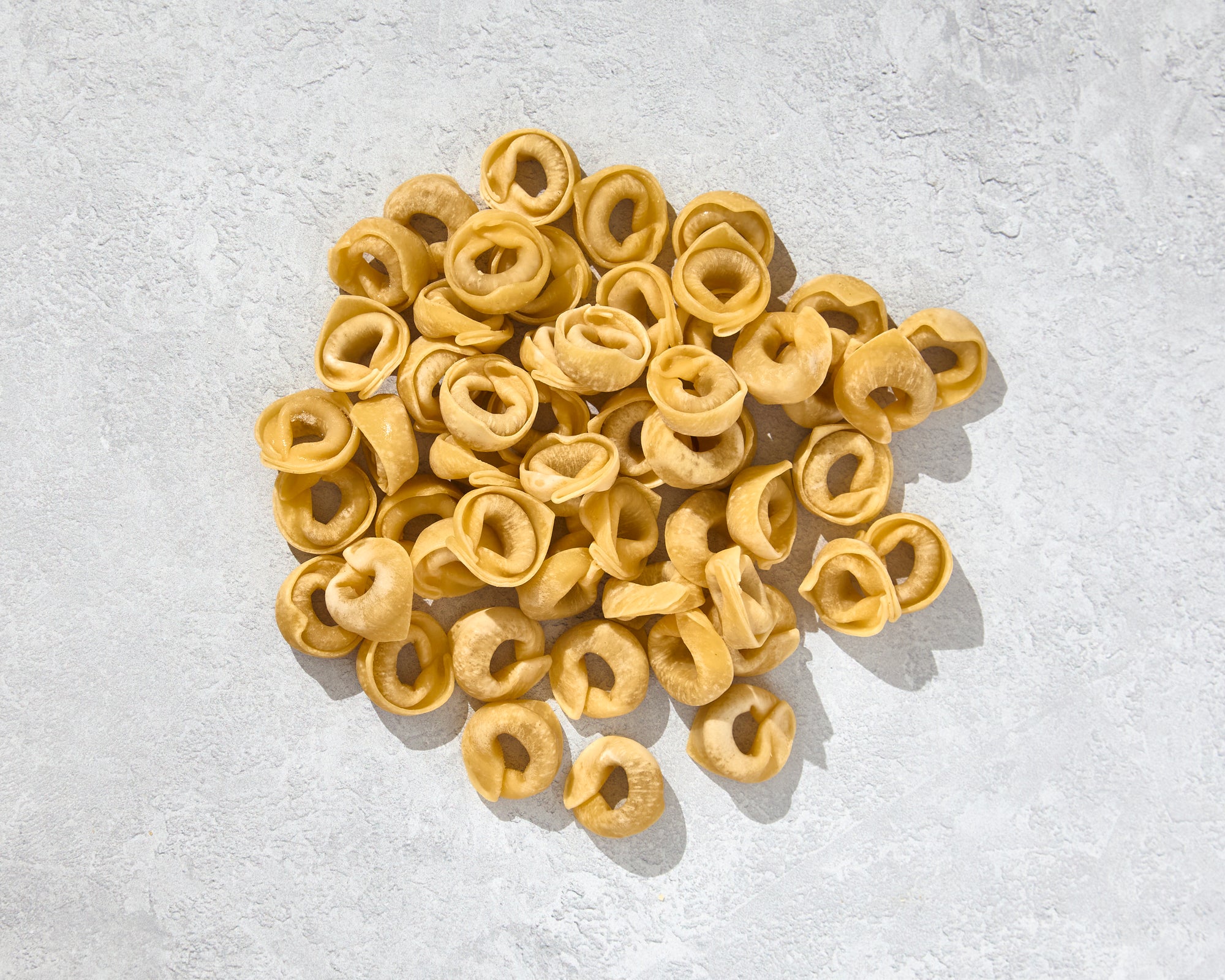 A top view of a pile of fresh tortellini pasta ready for cooking.
