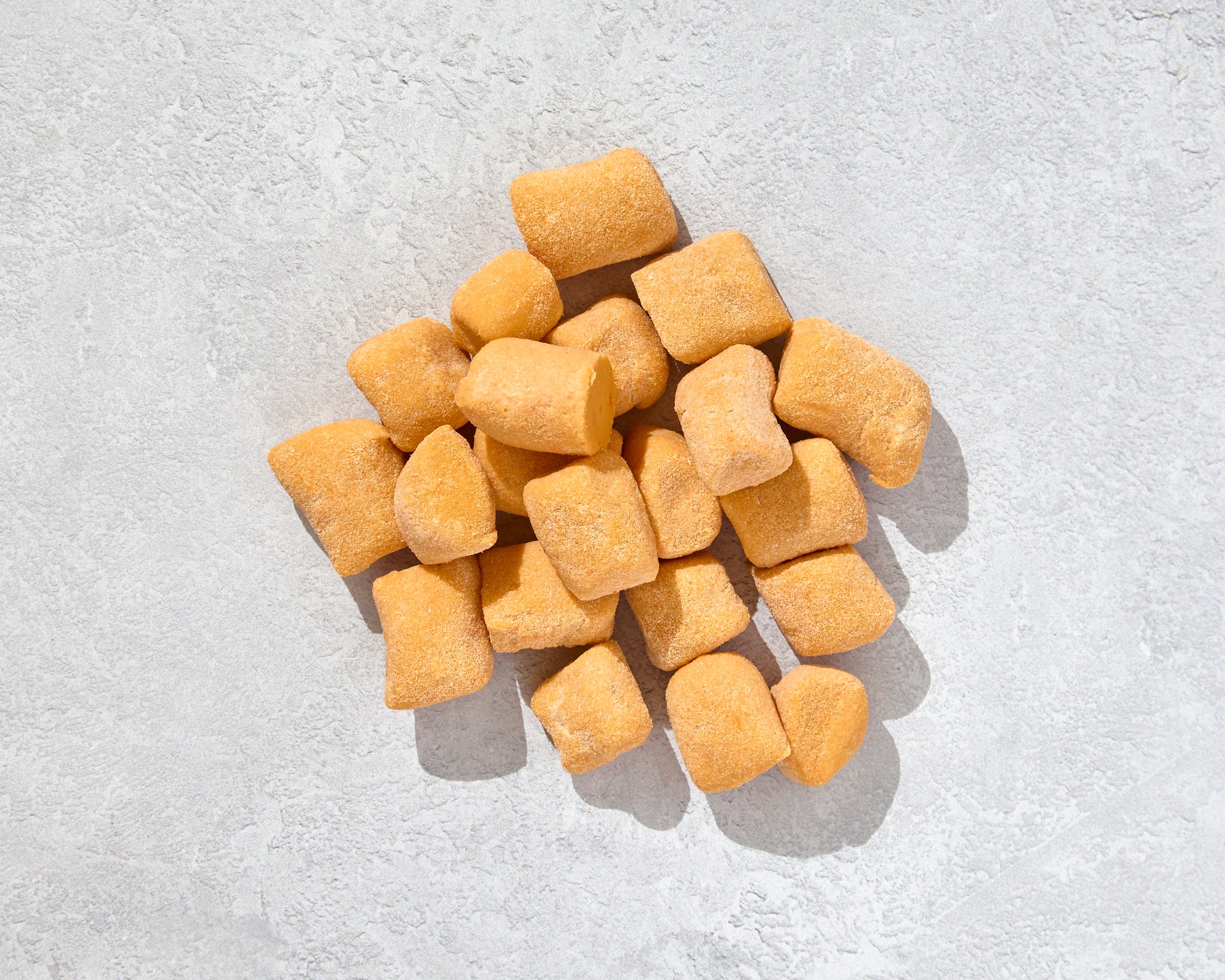 stack of fresh sweet potato gnocchi on a light surface